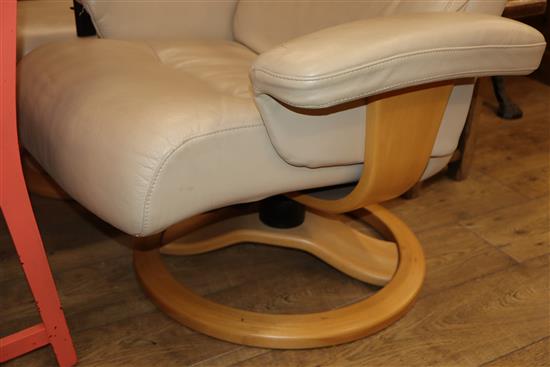 A cream leather reclining armchair and footstool